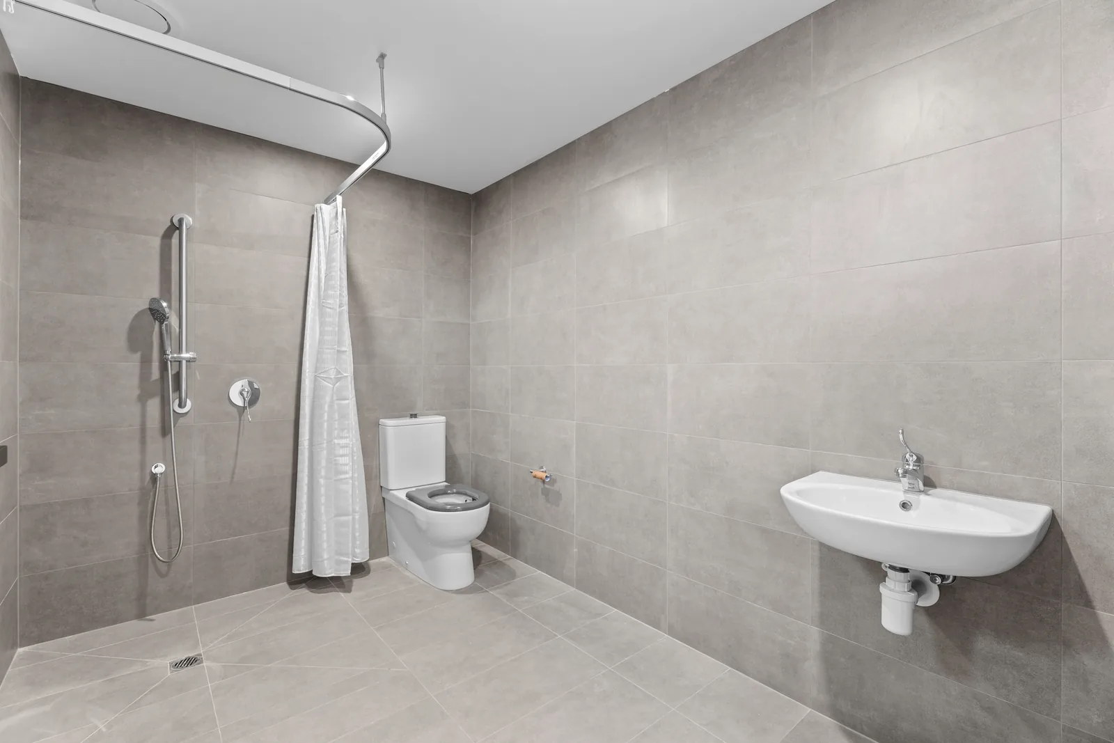 Accessible bathroom with a roll in shower and grab rails