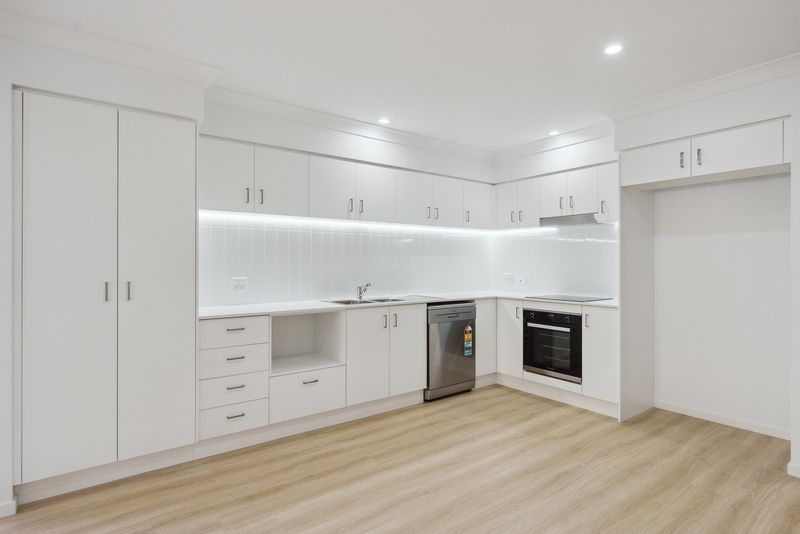 Kitchen with built-in appliances and long benchtop