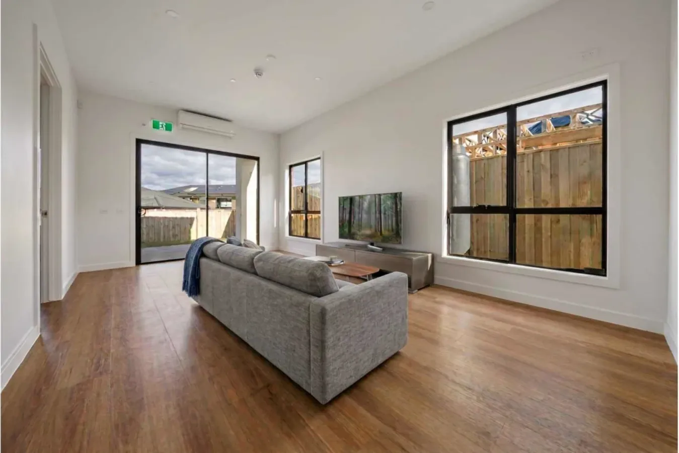 Open living space with a sofa and full-height windows on two sides