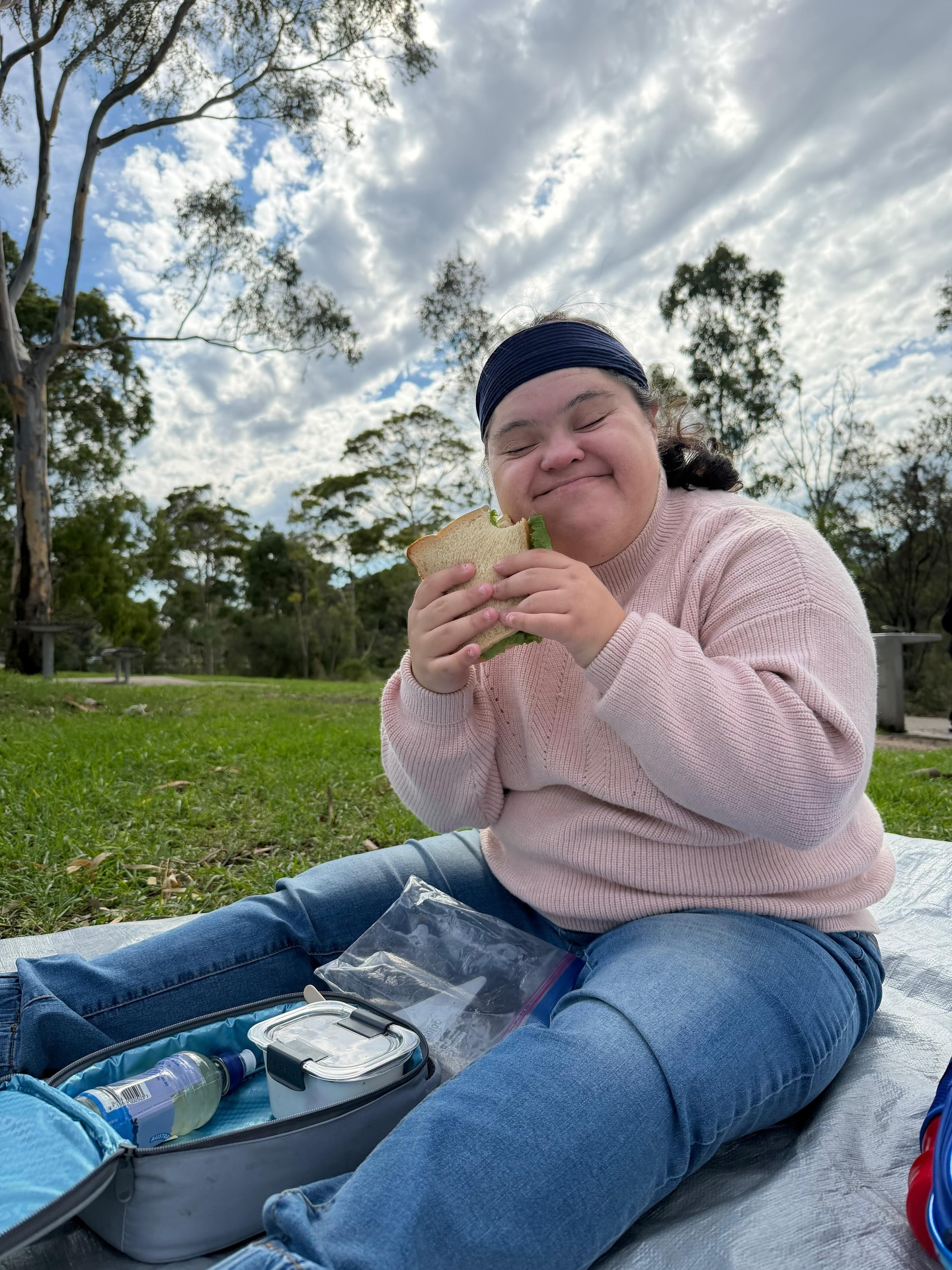 A participant enjoying an outdoor picnic with their support worker