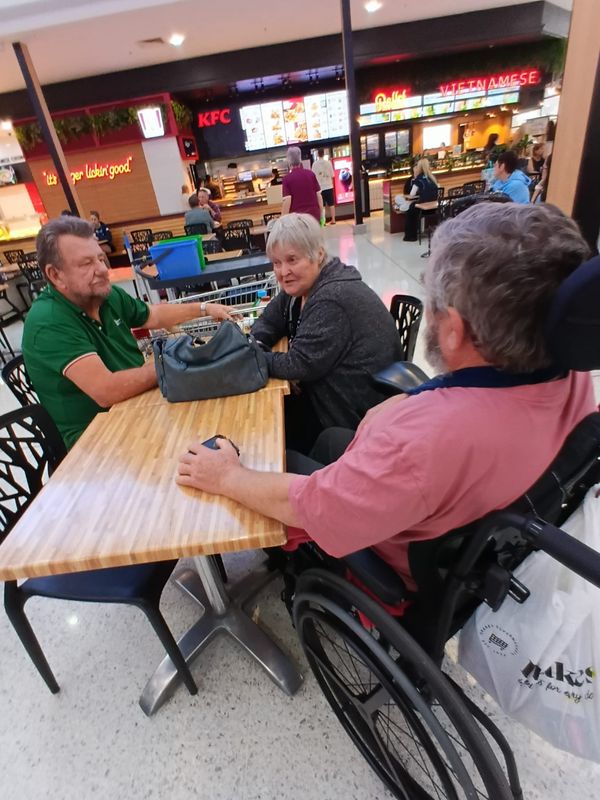 Participants and support workers sharing a meal out together
